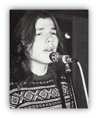 Young singer performing on stage with a microphone.