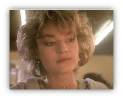 Young woman with curly hair, gazing thoughtfully in a retro setting.
