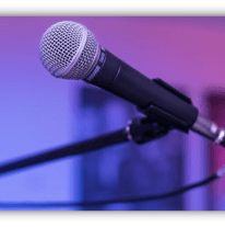 Microphone on a stand with a blurred colorful background.