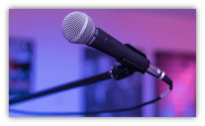 Microphone on a stand with a blurred colorful background.