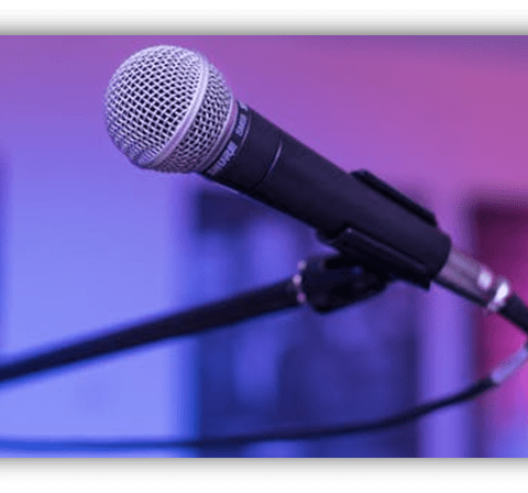 Microphone on a stand with a blurred colorful background.