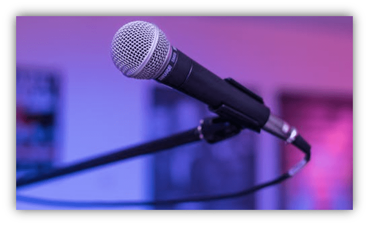 Microphone on a stand with a blurred colorful background.
