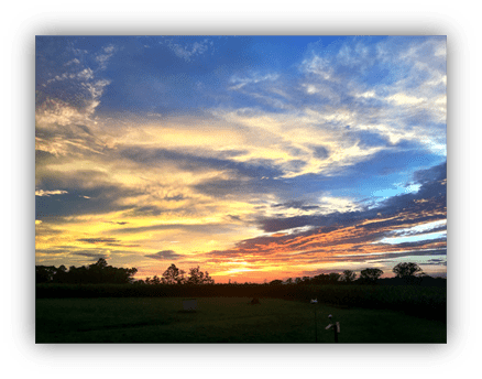 "Vibrant sunset over a serene landscape with colorful clouds."