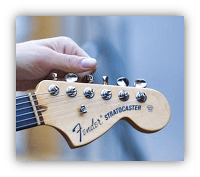 "Close-up of a hand holding a Fender Stratocaster guitar headstock."