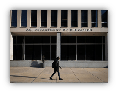 Person walking by the U.S. Department of Education building.