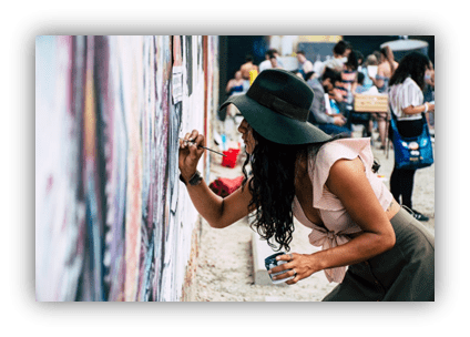 "Artist painting a mural at a vibrant outdoor event."