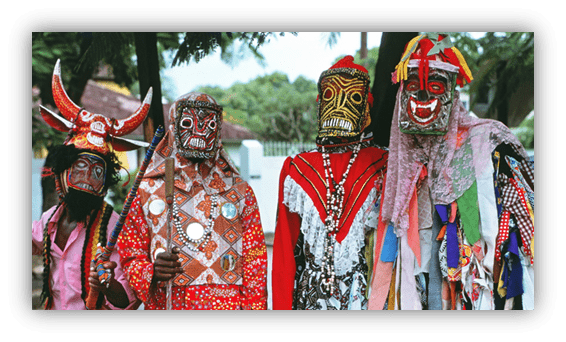 Traditional masked performers in vibrant costumes at a cultural festival.
