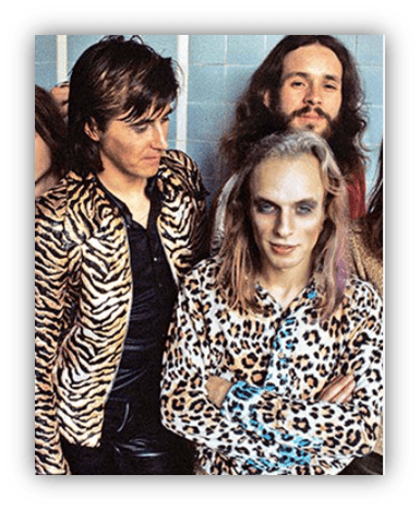"Vintage rock band in animal print outfits, posing together."