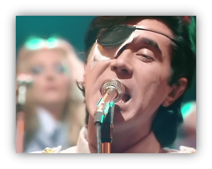 "Male singer with an eye patch performing on stage."