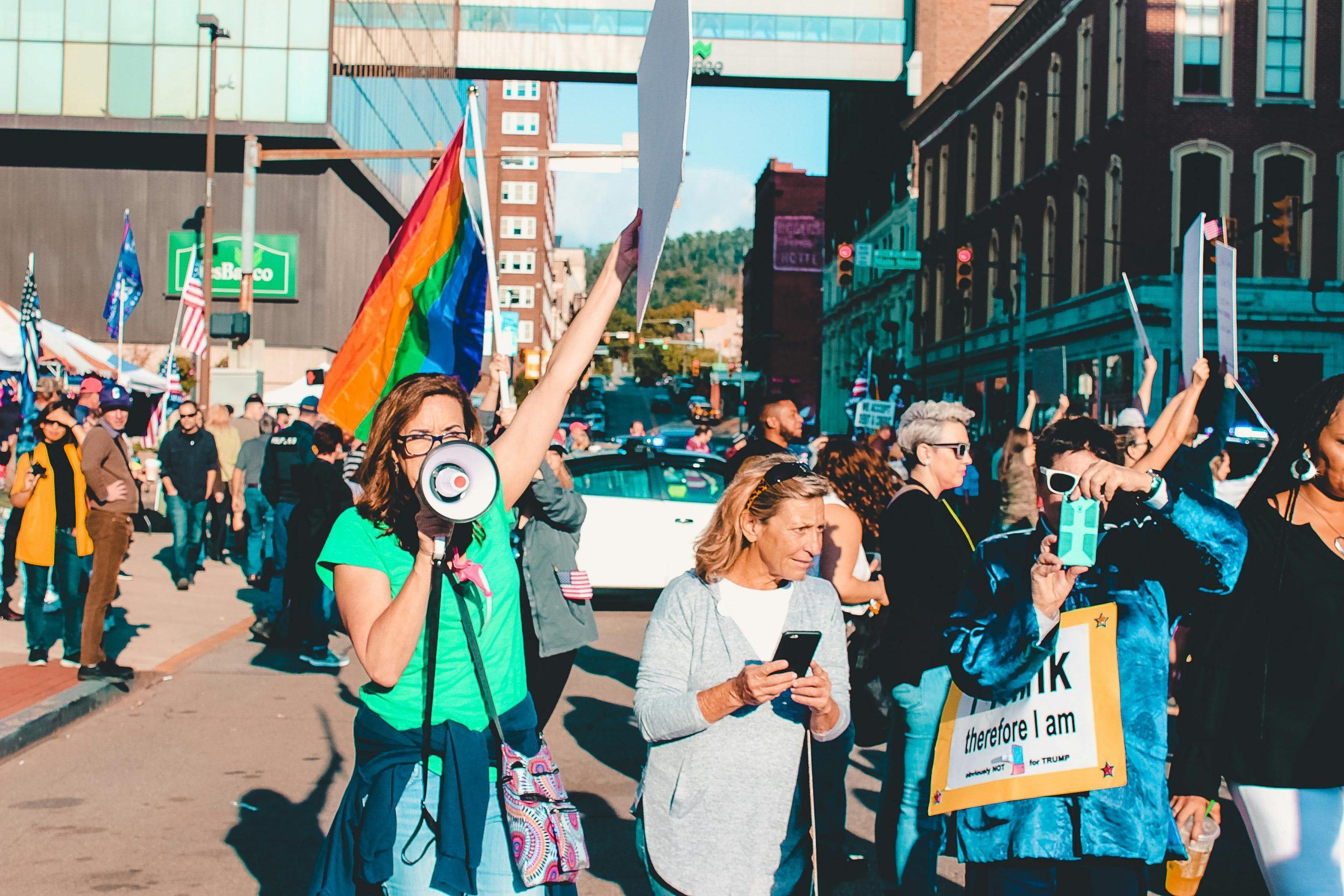 "Protesters rallying with signs and flags in a vibrant urban setting."